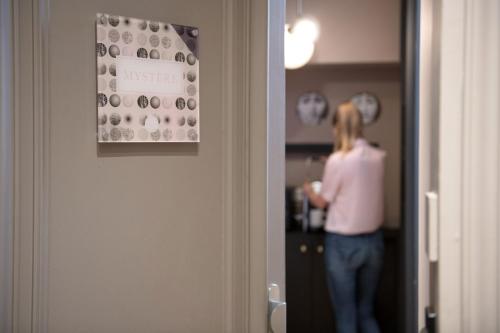 a woman is standing in a room with a wall at MiHotel Gailleton in Lyon