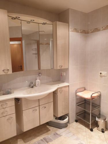 a bathroom with a sink and a mirror and a stool at Monteurzimmer Röderland - Langzeitaufenthalte für bis zu 6 Personen in Prösen