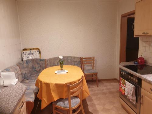 a kitchen with a table with a vase of flowers on it at Monteurzimmer Röderland - Langzeitaufenthalte für bis zu 6 Personen in Prösen
