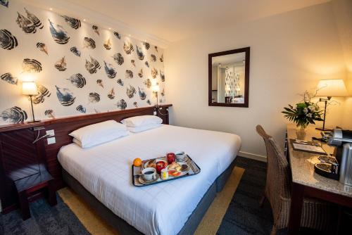 a hotel room with a tray of food on a bed at Hôtel La Villefromoy in Saint Malo