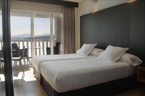 a hotel room with two beds and a balcony at Hotel Chiqui in Santander