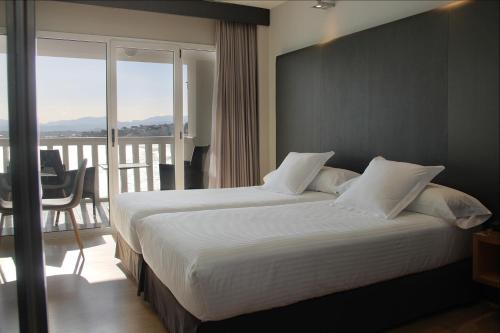 a hotel room with two beds and a large window at Hotel Chiqui in Santander