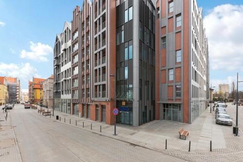 um grande edifício numa rua da cidade com carros em Grano Residence - Pool, Sauna, SPA & Parking by Downtown Apartments em Gdansk