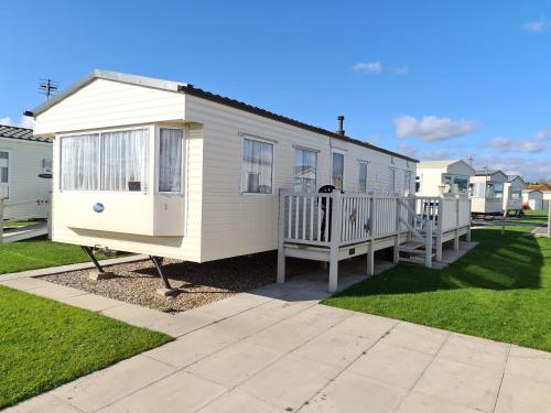 a tiny house in a yard with a fence at Golden Palm - Meadow Lakes in Chapel Saint Leonards