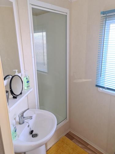 a white bathroom with a sink and a mirror at Golden Palm - Meadow Lakes in Chapel Saint Leonards