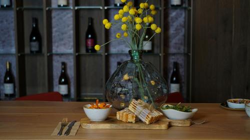 a vase with yellow flowers and snacks on a table at Mercure Valence in Valence