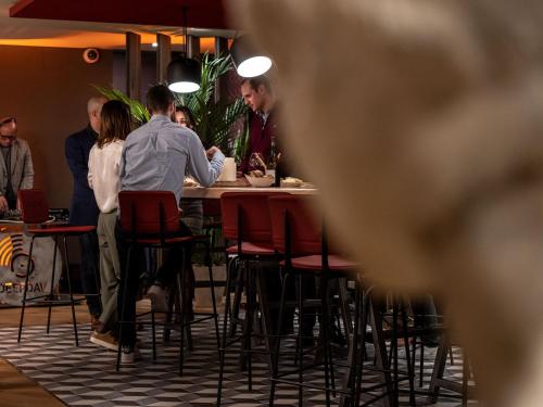 a group of people sitting at a table in a restaurant at Mercure Valence in Valence