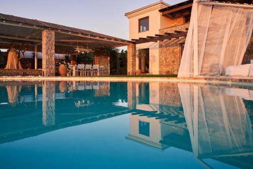 a house with a swimming pool in front of a house at The Editor's Villa - Member of Spiritual Living Corfu in Virós
