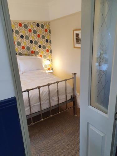 a small bedroom with a bed in a room at The Lodge Stanwell in Stanwell