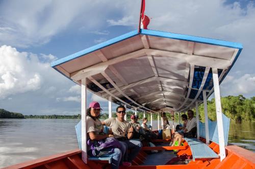 a group of people on a boat on the water at Monte Amazonico Lodge in Tambopata