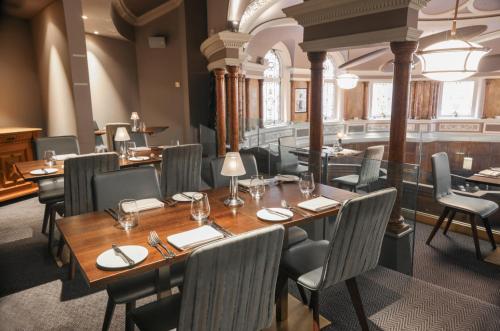 a restaurant with a wooden table and chairs at Hotel Indigo - Durham by IHG in Durham