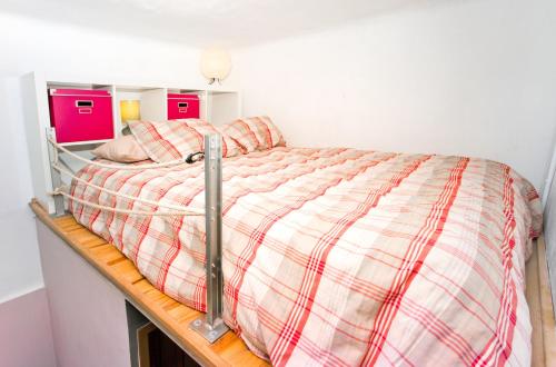 uma cama com um cobertor xadrez num quarto em Estudio Finestrelles em Barcelona