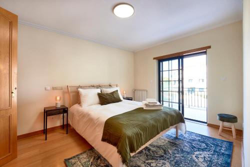 a bedroom with a bed and a large window at Carcavelos Apartment in Carcavelos