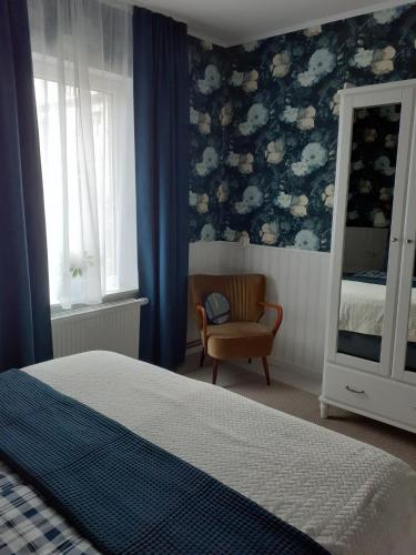 una camera da letto con letto, sedia e pareti blu di Blaue Welle a Varel