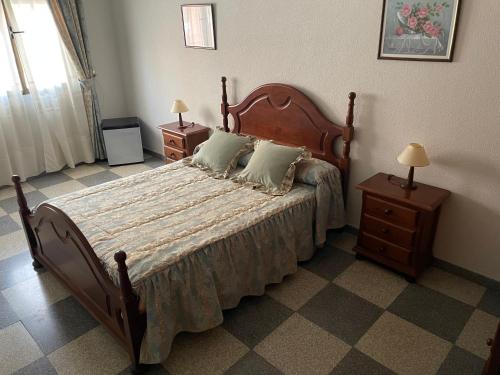 Hostal Las Palomas في La Calzada de Calatrava: غرفة نوم بسرير كبير وموقف ليلتين