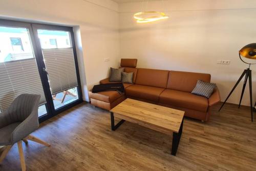 a living room with a couch and a coffee table at Chaletwohnung vor den Toren des Chiemgaus in Tacherting