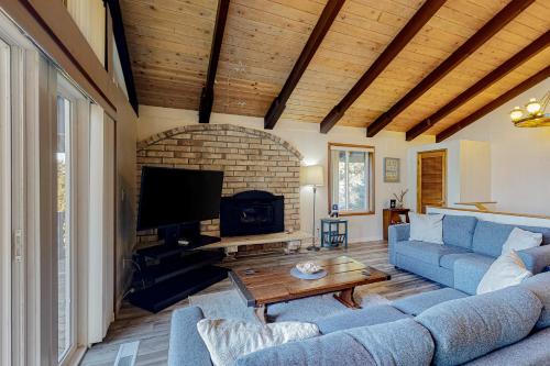 a living room with a blue couch and a tv at Rockaway Beach House in Rockaway Beach