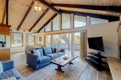 a living room with a blue couch and a tv at Rockaway Beach House in Rockaway Beach