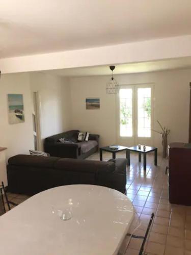 un salon avec un canapé et une table dans l'établissement Maison proche bord de mer, à Guissény