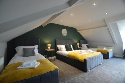 1 dormitorio con 2 camas y pared verde en Spacious and Homely 3 Bedroom Flat - SuiteLivin en Gateshead