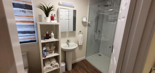 a bathroom with a glass shower and a sink at Meadows 2 in Auldearn
