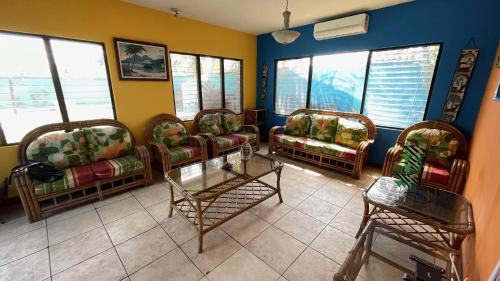 a waiting room with chairs and a table and windows at Chalet en Puerto San Jose in San José de Guatemala