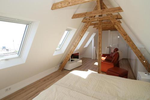 a room with a bed and a chair in a attic at Am Wasser 4 OG in Hörnum