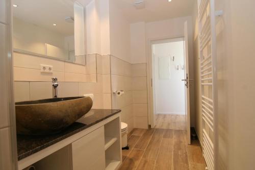 a bathroom with a stone sink on a counter at Am Wasser 4 OG in Hörnum