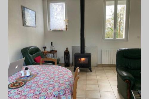 - un salon avec une table et une cheminée dans l'établissement Maison de campagne avec jardin pour 2 à 5 personnes, à Julos