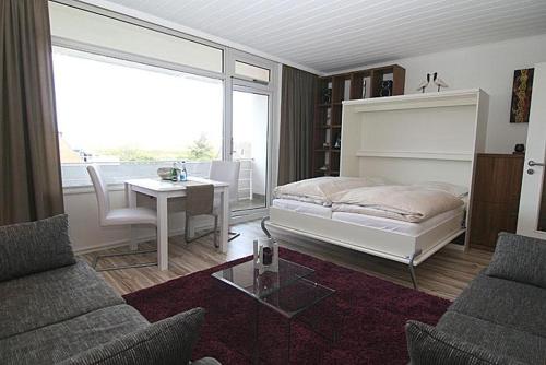 Schlafzimmer mit einem Bett, einem Tisch und Stühlen in der Unterkunft Ferienwohnung Ferlings in Hörnum