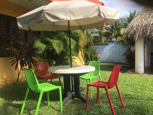 a table with four chairs and an umbrella at Chalet en Puerto San Jose in San José de Guatemala