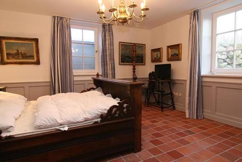 sypialnia z łóżkiem, oknem i żyrandolem w obiekcie Friesenstube w mieście Hörnum