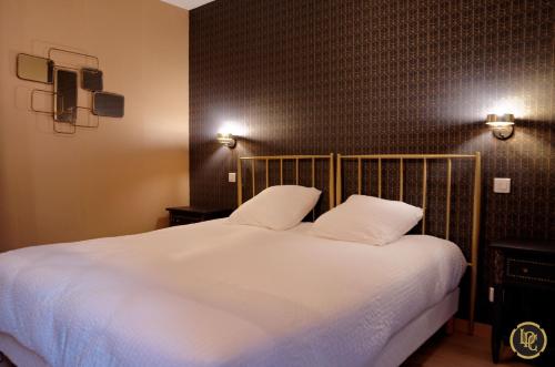 a bedroom with a large white bed with two pillows at Maison d'hôtes "La Pause Champenoise" in Champfleury