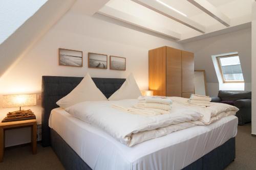 ヘルヌムにあるHaus Emilia - Appartement Leuchtturmのベッドルーム(白いシーツを使用した大型ベッド1台付)