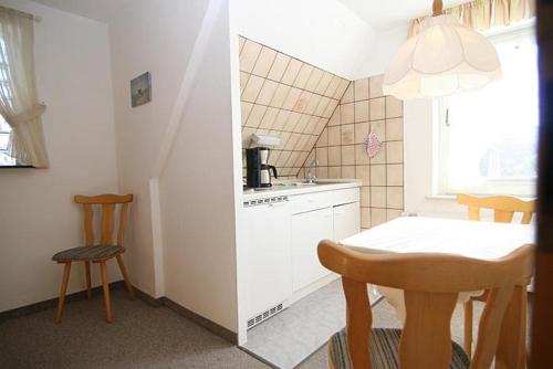 a small kitchen with a table and a table and chairs at Haus Gräpel App 1 in Hörnum