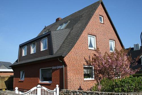 a large red brick house with a black roof at Haus Gräpel App 1 in Hörnum