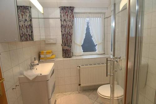 ヘルヌムにあるHaus Gräpel App 3のバスルーム(トイレ、洗面台付)、窓が備わります。