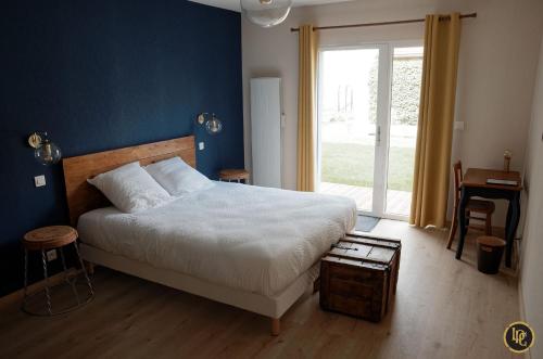 - une chambre dotée d'un lit avec un mur bleu dans l'établissement Maison d'hôtes "La Pause Champenoise", à Champfleury