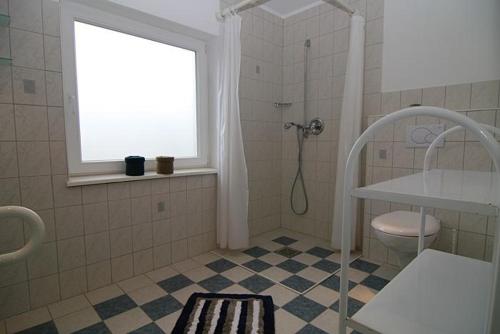 ヘルヌムにあるHaus Roseneck App.1のバスルーム(シャワー、トイレ付)、窓が備わります。