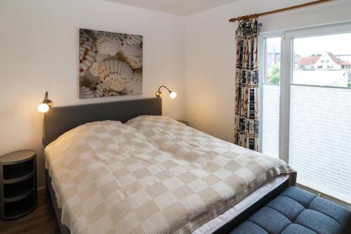 a bedroom with a bed and a large window at Haus Roseneck App.2 in Hörnum