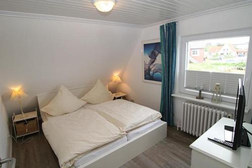 ヘルヌムにあるHaus Roseneck App.4のベッドルーム1室(ベッド1台、デスク、窓付)