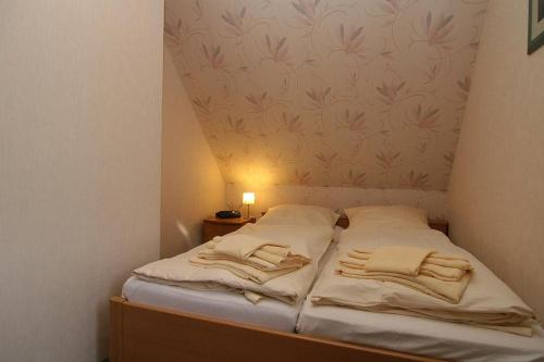 ein kleines Bett mit zwei Handtüchern darüber in der Unterkunft Haus Schumacher, Wohnung 1 in Hörnum