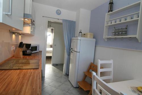 a kitchen with a white refrigerator and a table at Lüddn Traum in Hörnum