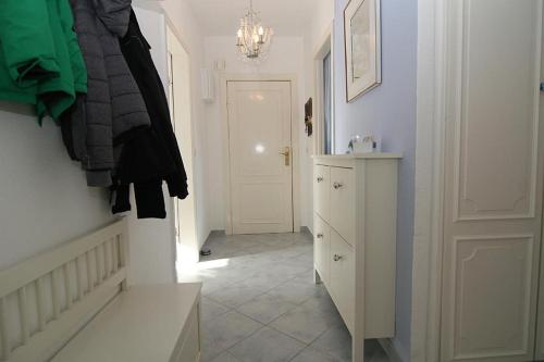 a hallway with a white cabinet and a white door at Lüddn Traum in Hörnum