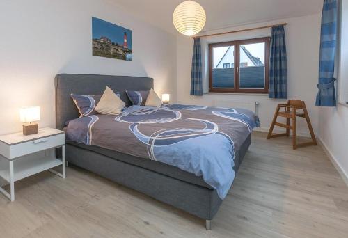 a bedroom with a bed and a desk and a window at Nils Holgerson NH2 in Hörnum