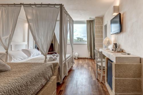 una camera con letto e TV e una camera da letto di Dimora Celeste a Ostuni