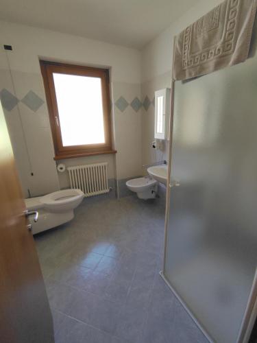 a bathroom with two toilets and a window and a shower at Residenza Arcobaleno in Tenno