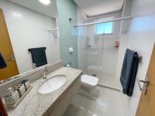a bathroom with a sink and a glass shower at SCHULZ Turtles Home in Guarapari