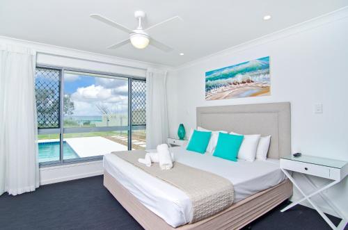 a bedroom with a bed and a large window at Sentosa on Tugun - Beachfront 5 Bedroom in Gold Coast