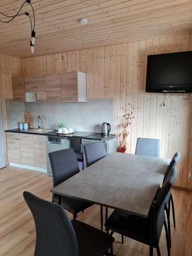 a kitchen and dining room with a table and chairs at Domek nad stawem in Robakowo